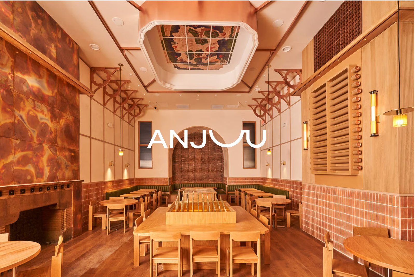 The Anjuu dining room — warm wood, copper and tiled walls with a long communal table