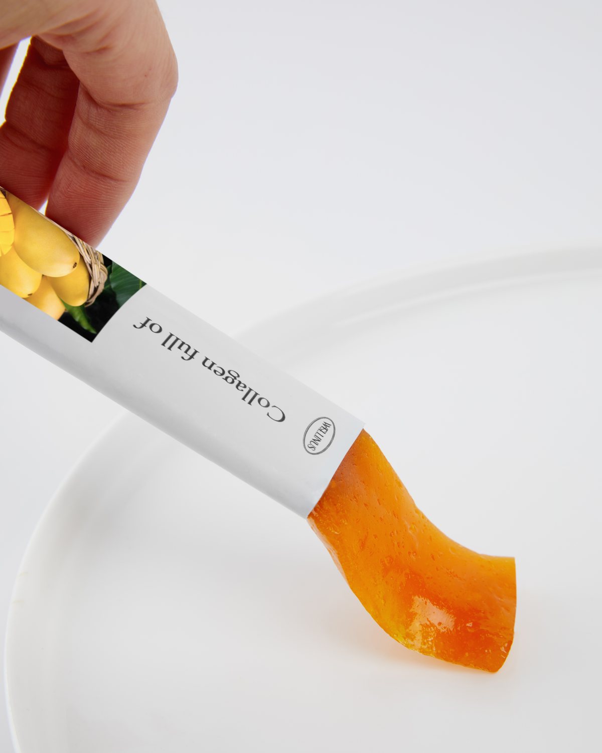 A Wellinus collagen jelly stick being squeezed onto a white plate